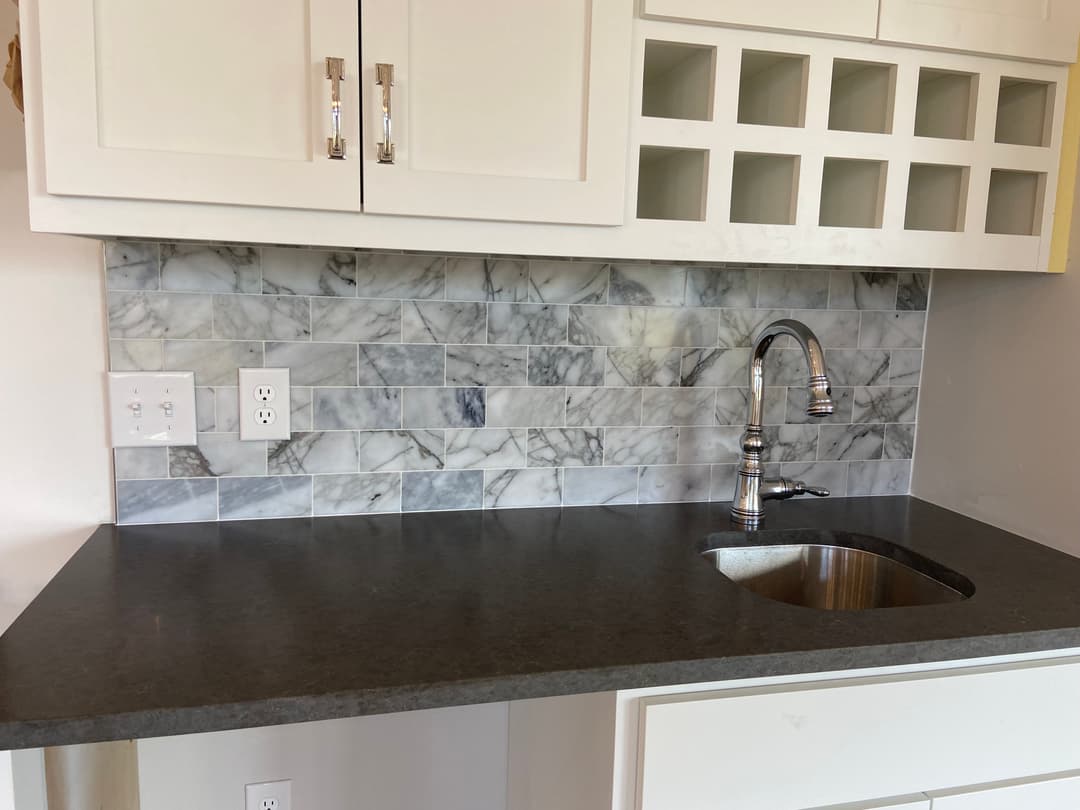 remodeled kitchen with granite tile backsplash