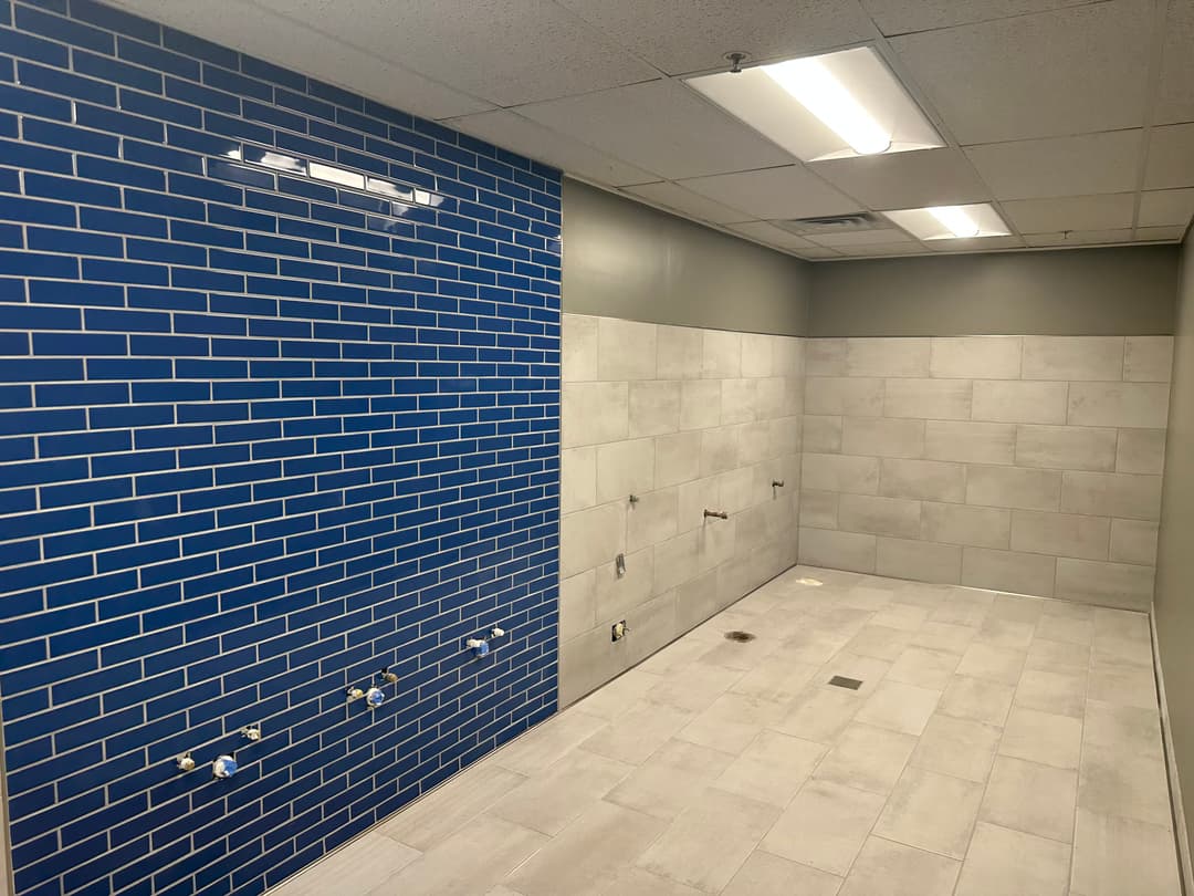 custom blue tile bathroom wall with gray tile shower flooring